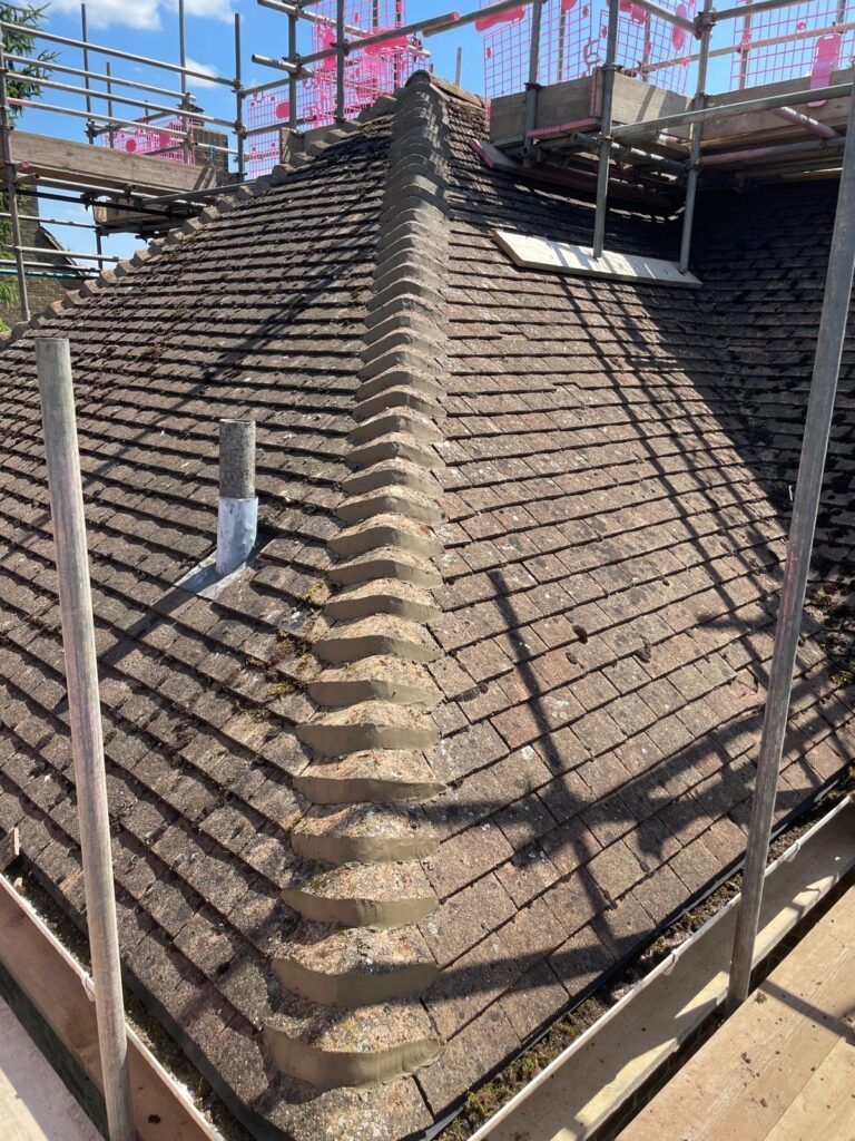 Tiled hip roof with scaffolding during roof work