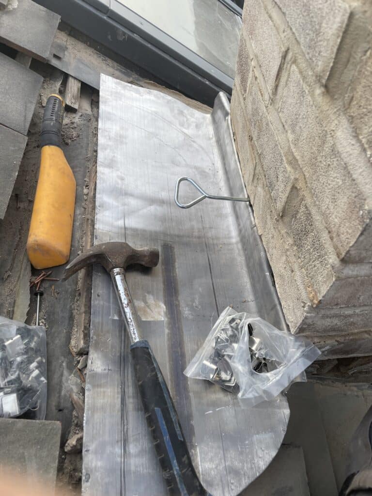 Lead flashing being dressed on a roof